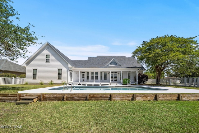 back of property featuring fence private yard, a fenced in pool, french doors, and a lawn