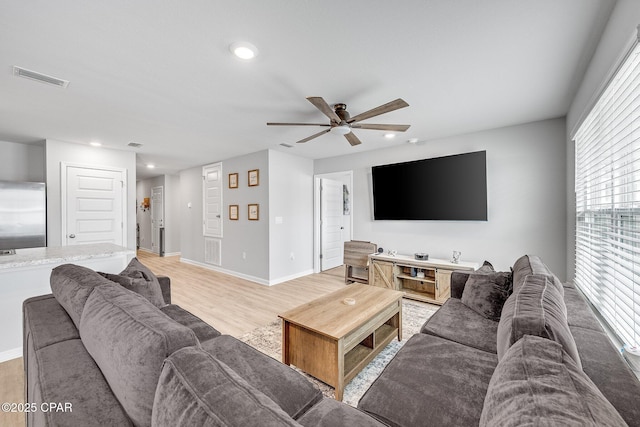 living room with light wood-type flooring, visible vents, ceiling fan, and recessed lighting