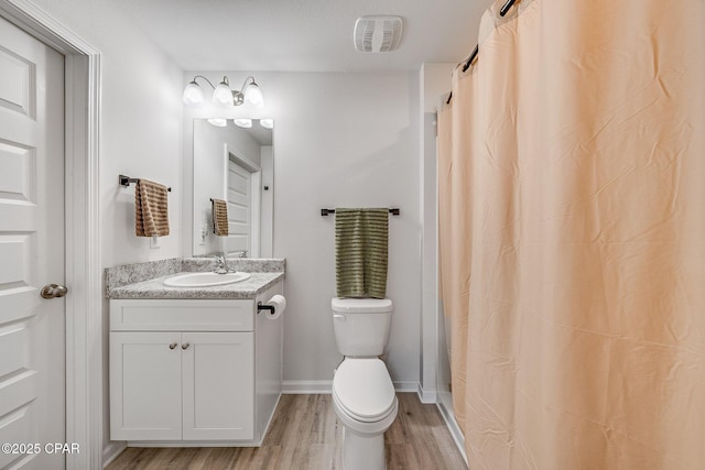 bathroom featuring curtained shower, visible vents, toilet, wood finished floors, and vanity