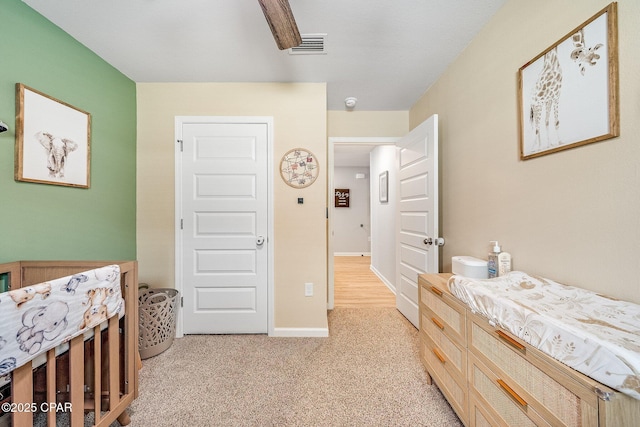 bedroom featuring baseboards, visible vents, and light carpet