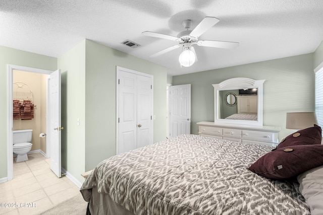 bedroom featuring light tile patterned floors, a textured ceiling, visible vents, and baseboards