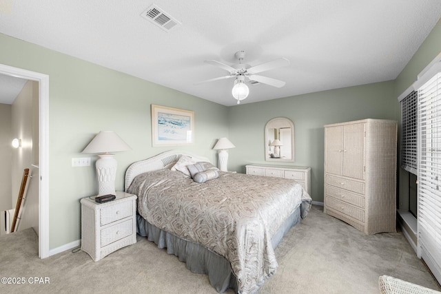 bedroom with baseboards, visible vents, light carpet, and ceiling fan