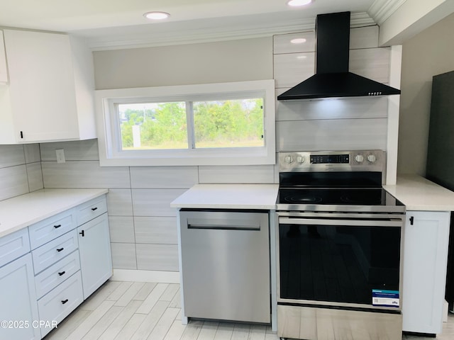 1003 E 8th St, Lynn Haven, FL 32444 - kitchen with stainless steel appliances, light countertops, ornamental molding, and wall chimney range hood