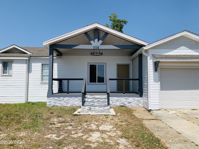 308 S Macarthur Ave, Panama City, FL 32401 - ranch-style home featuring covered porch, an attached garage, a shingled roof, and stone siding