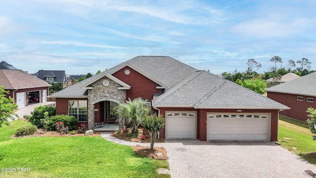 view of front of property with decorative driveway, an attached garage, stone siding, and a front yard