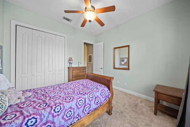 carpeted bedroom featuring baseboards, visible vents, ceiling fan, and a closet