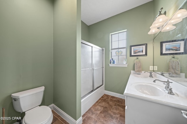 bathroom featuring baseboards, a sink, double vanity, and toilet