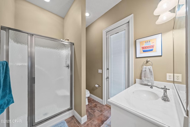 full bathroom featuring vanity, toilet, tile patterned floors, baseboards, and a stall shower