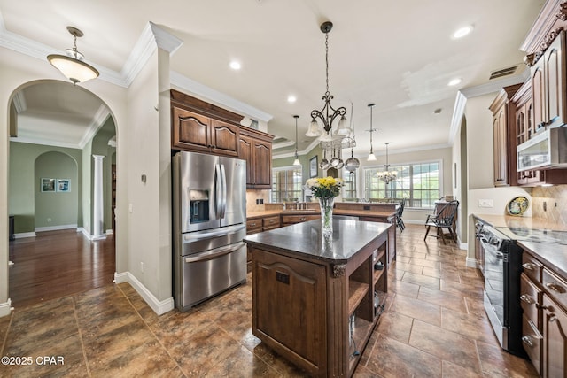 kitchen featuring black range with electric cooktop, a peninsula, a kitchen island, baseboards, and stainless steel fridge