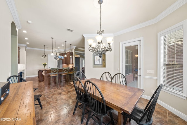 dining area featuring visible vents, crown molding, arched walkways, baseboards, and a notable chandelier
