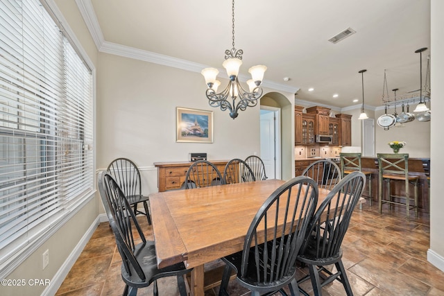 dining space featuring crown molding, baseboards, a notable chandelier, and visible vents