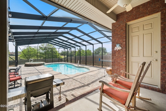 view of pool with a lanai, a ceiling fan, a pool with connected hot tub, a fenced backyard, and a patio