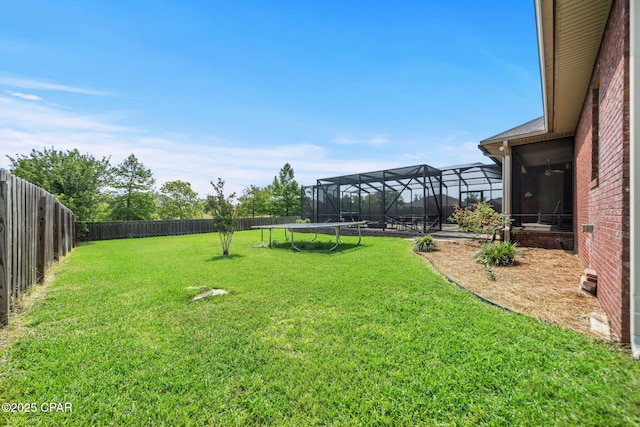 view of yard featuring glass enclosure and a fenced backyard
