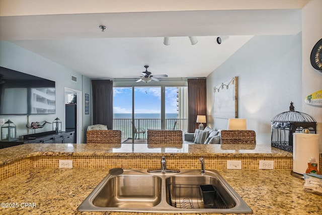 9900 S Thomas Dr Unit 1418, Panama City Beach, FL 32408 - kitchen featuring light stone counters, a sink, visible vents, a water view, and a ceiling fan