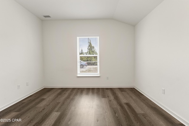 unfurnished room featuring visible vents, dark wood-style flooring, baseboards, and vaulted ceiling