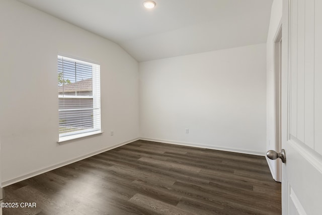 empty room with baseboards, dark wood finished floors, and lofted ceiling