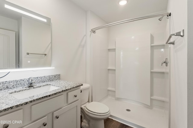 bathroom with vanity, toilet, and a stall shower