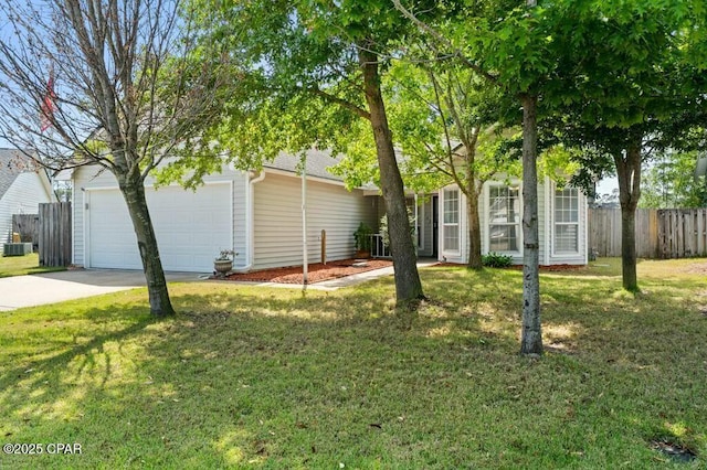 view of front of house with concrete driveway, a front lawn, an attached garage, and fence