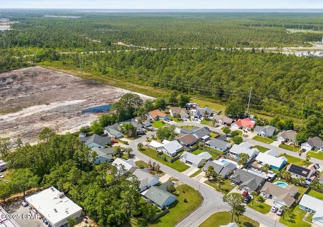birds eye view of property featuring a wooded view and a residential view