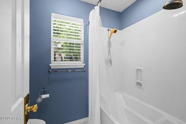 full bath featuring shower / bath combo and baseboards