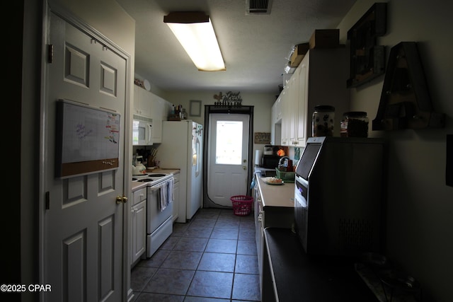kitchen featuring light tile patterned floors, white appliances, visible vents, light countertops, and white cabinets