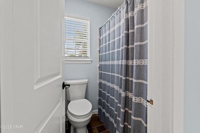 bathroom with toilet and a shower with curtain