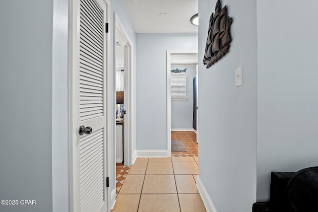 hallway featuring light tile patterned flooring and baseboards