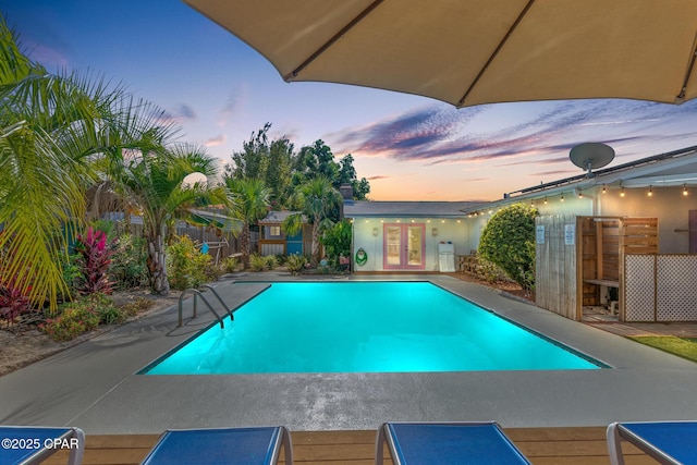 view of swimming pool featuring french doors, a fenced in pool, and a patio area