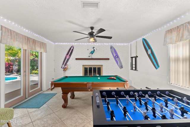 recreation room with visible vents, tile patterned flooring, brick wall, a textured ceiling, and billiards