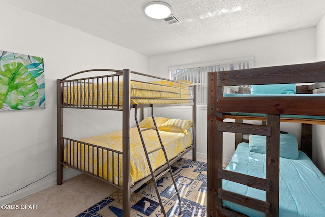 bedroom featuring a textured ceiling and visible vents