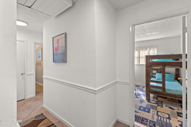 corridor featuring tile patterned flooring and a textured ceiling