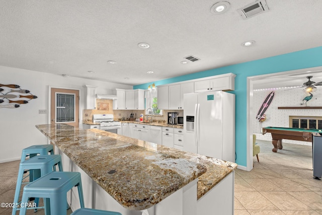 kitchen with a sink, white appliances, white cabinetry, pool table, and visible vents