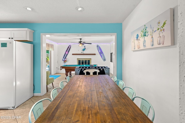 dining room featuring billiards, a brick fireplace, ceiling fan, and light tile patterned flooring