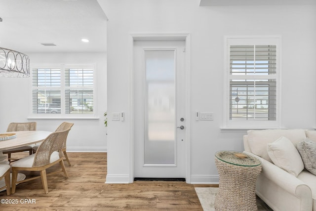 entrance foyer featuring baseboards, a chandelier, and plenty of natural light
