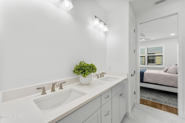 bathroom with double vanity, visible vents, a sink, and marble finish floor