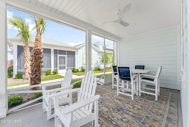 sunroom / solarium featuring ceiling fan and outdoor dining space