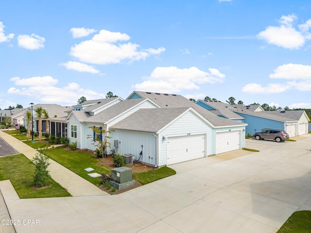 view of front of house featuring roof with shingles, a residential view, a garage, central AC, and concrete driveway