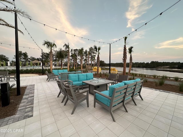 view of patio / terrace with a water view and an outdoor living space with a fire pit