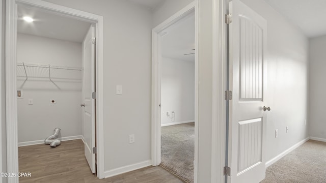 laundry area with hookup for an electric dryer, wood finished floors, laundry area, and baseboards