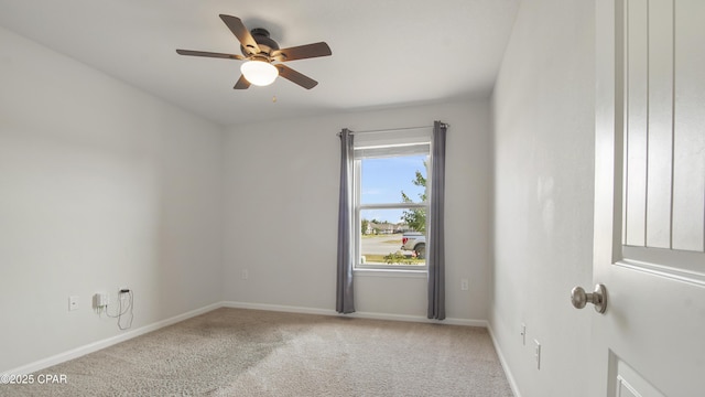 empty room featuring baseboards, light carpet, and ceiling fan