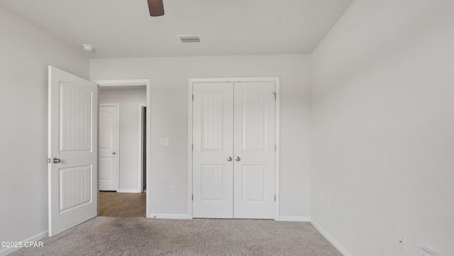 unfurnished bedroom with carpet floors, a closet, baseboards, visible vents, and a ceiling fan