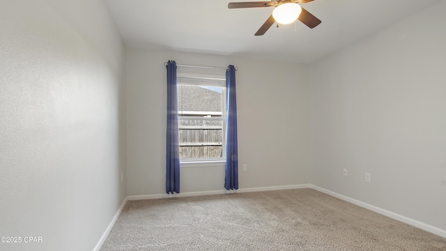 carpeted empty room featuring ceiling fan and baseboards