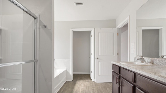 full bathroom featuring visible vents, a garden tub, a stall shower, wood finished floors, and vanity