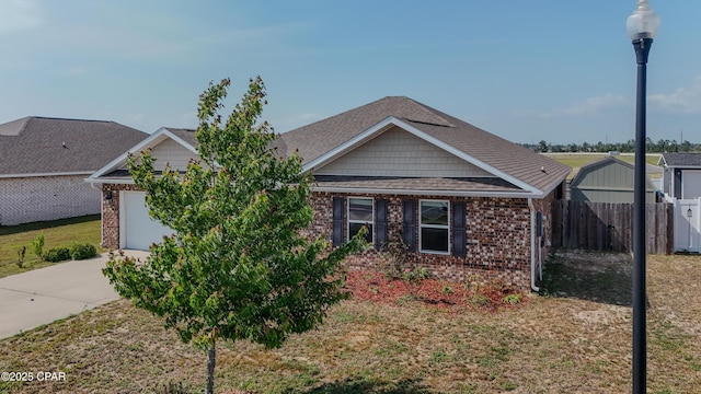 view of front facade with fence, driveway, and brick siding