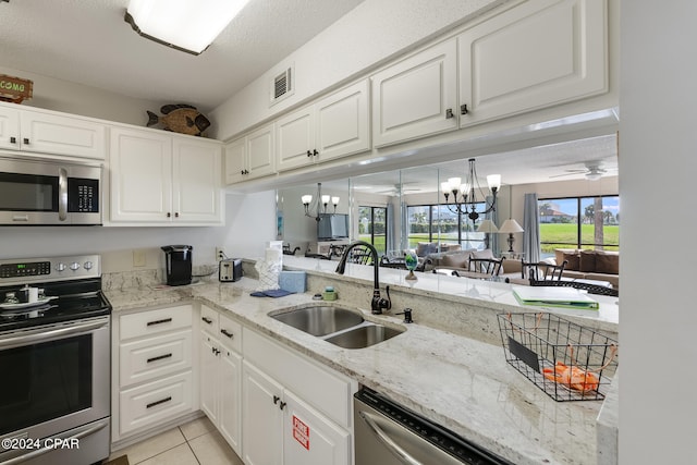 kitchen featuring a sink, visible vents, white cabinets, appliances with stainless steel finishes, and open floor plan