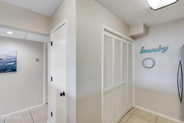 corridor featuring light tile patterned floors and baseboards