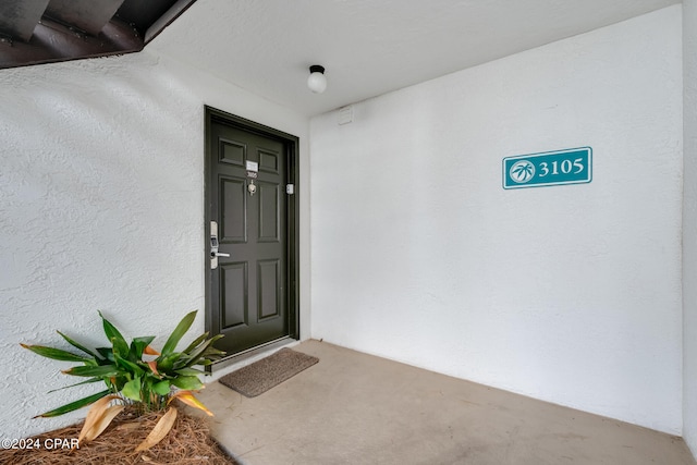 entrance to property featuring stucco siding