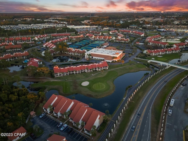 drone / aerial view with golf course view and a water view