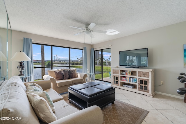 tiled living area with baseboards, ceiling fan, and a textured ceiling