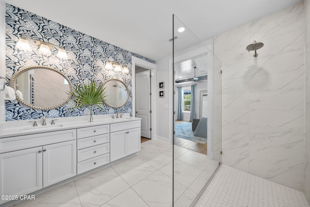 bathroom featuring marble finish floor, a sink, a walk in shower, and double vanity